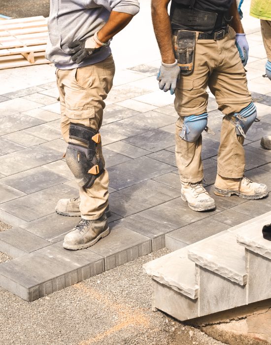 Three,Construction,Workers,Working,On,Landscaping,Construction,Site,,Laying,Paving