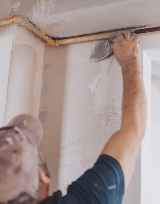 Plasterer,Using,A,Finishing,Trowel,To,Smooth,New,Plaster,On