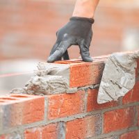 Skilled,Craftsman,Laying,Bricks,For,New,Wall,In,Construction,Project
